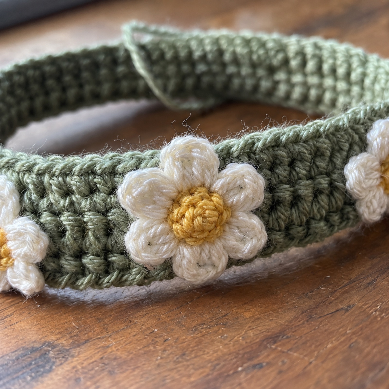 Close-up of a tiny white daisy stitched onto the ribbed band on the Daisy Chain Headband