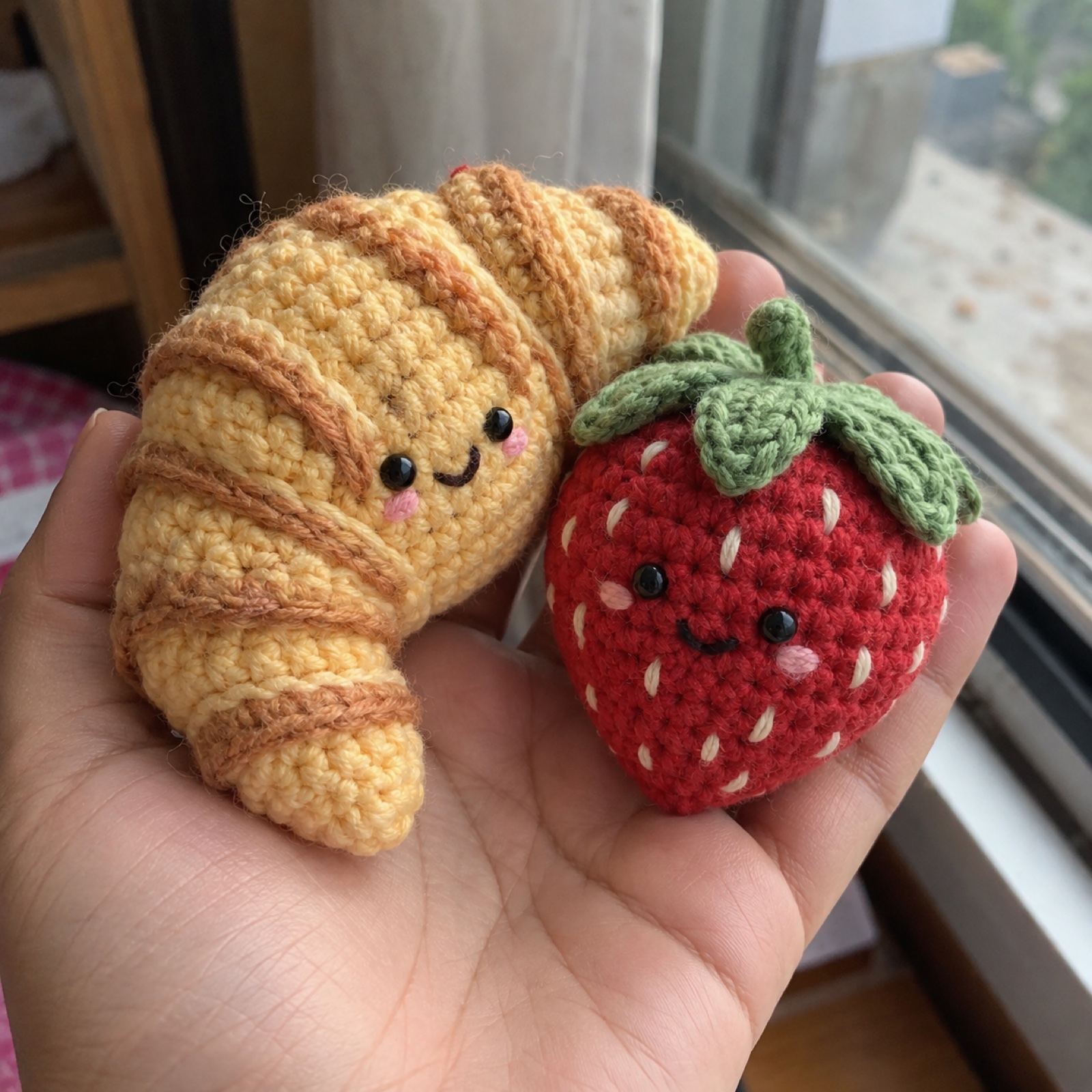 Close-up of the strawberry's embroidered seeds and leafy green cap on the Strawberry & Croissant Snack Plush Set
