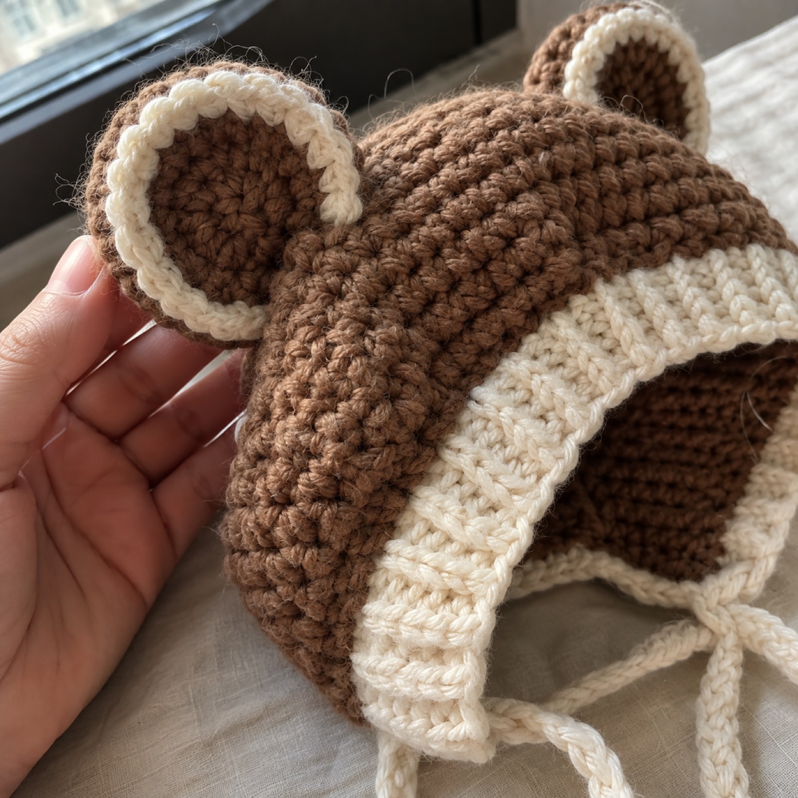 Close-up of a round bear ear and the cream ribbed edge on the Bear Ear Baby Bonnet