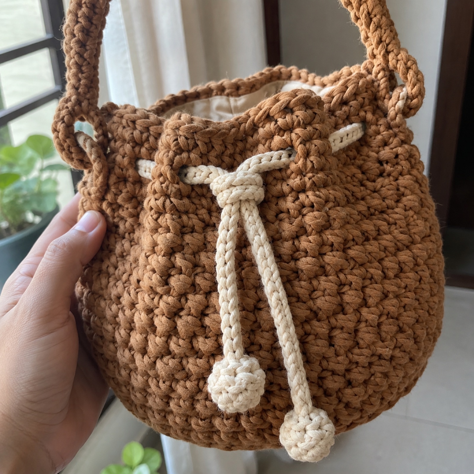 Close-up of the chunky braided-cord stitches and drawstring eyelets on the Chunky Cord Bucket Bag