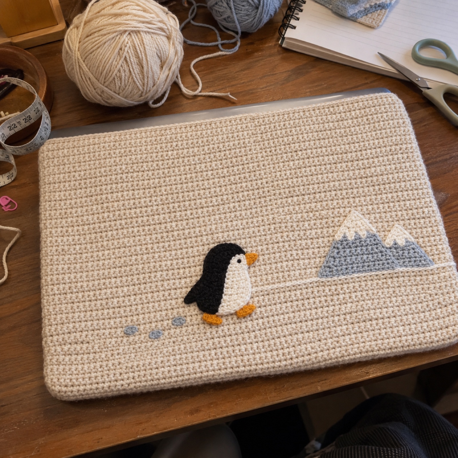 Logging Off Penguin Lid: handmade crochet laptop top cover with a walking away penguin appliqué
