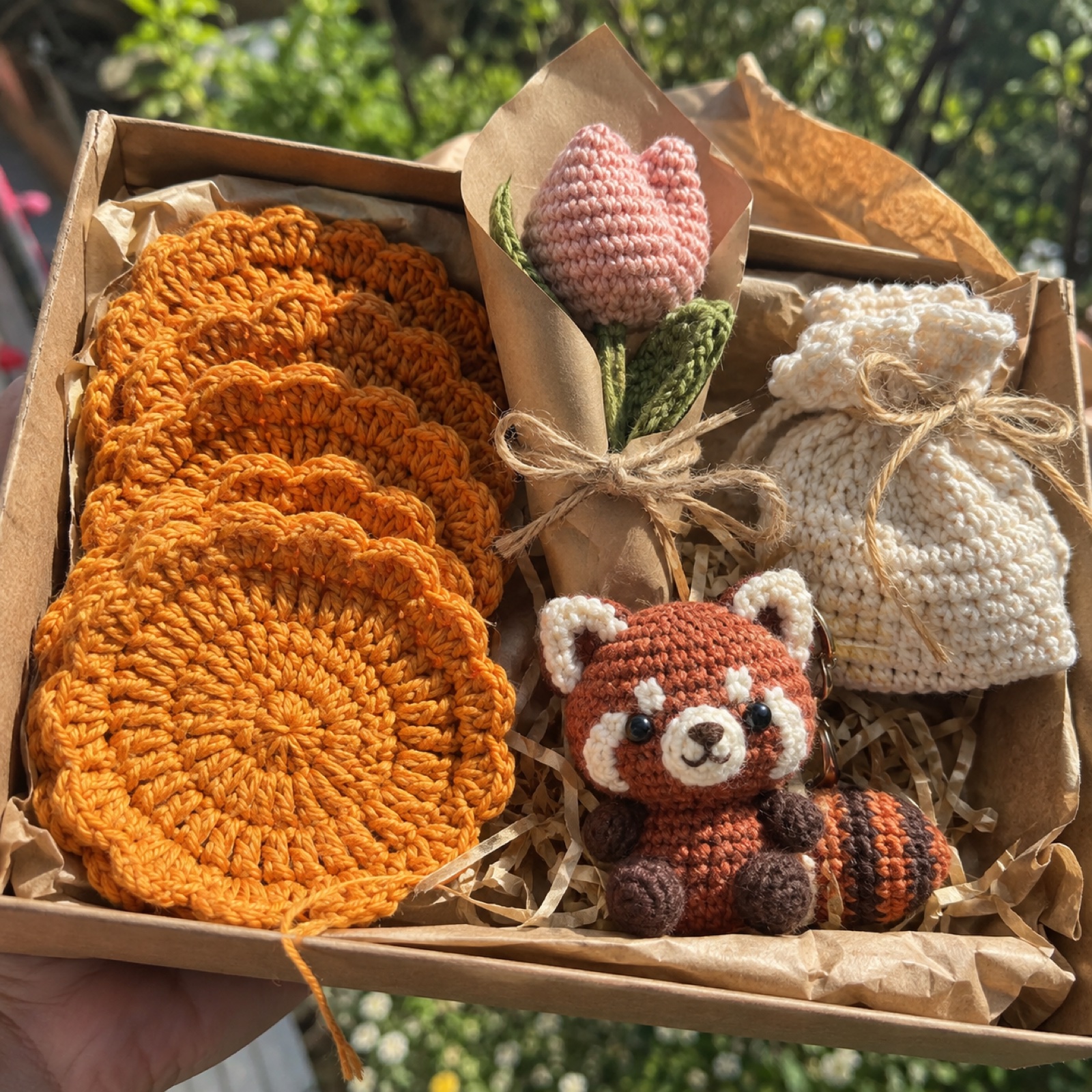 Close-up of the stacked marigold coasters' stitch rounds beside the tiny red panda on the Festive Celebration Hamper