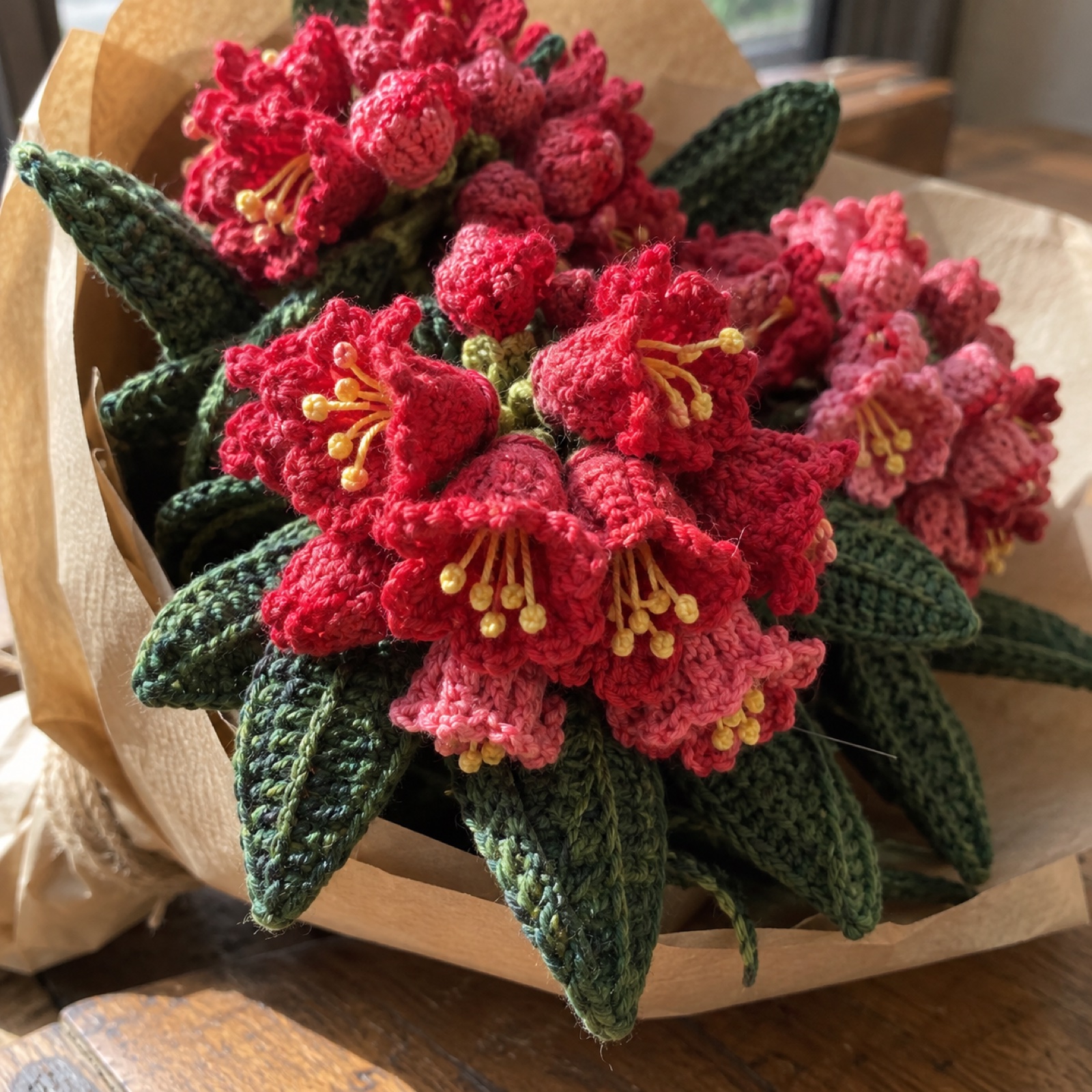 Close-up of a cluster of crimson bell-shaped blooms with yellow stamen stitches on the Rhododendron Hill Bouquet