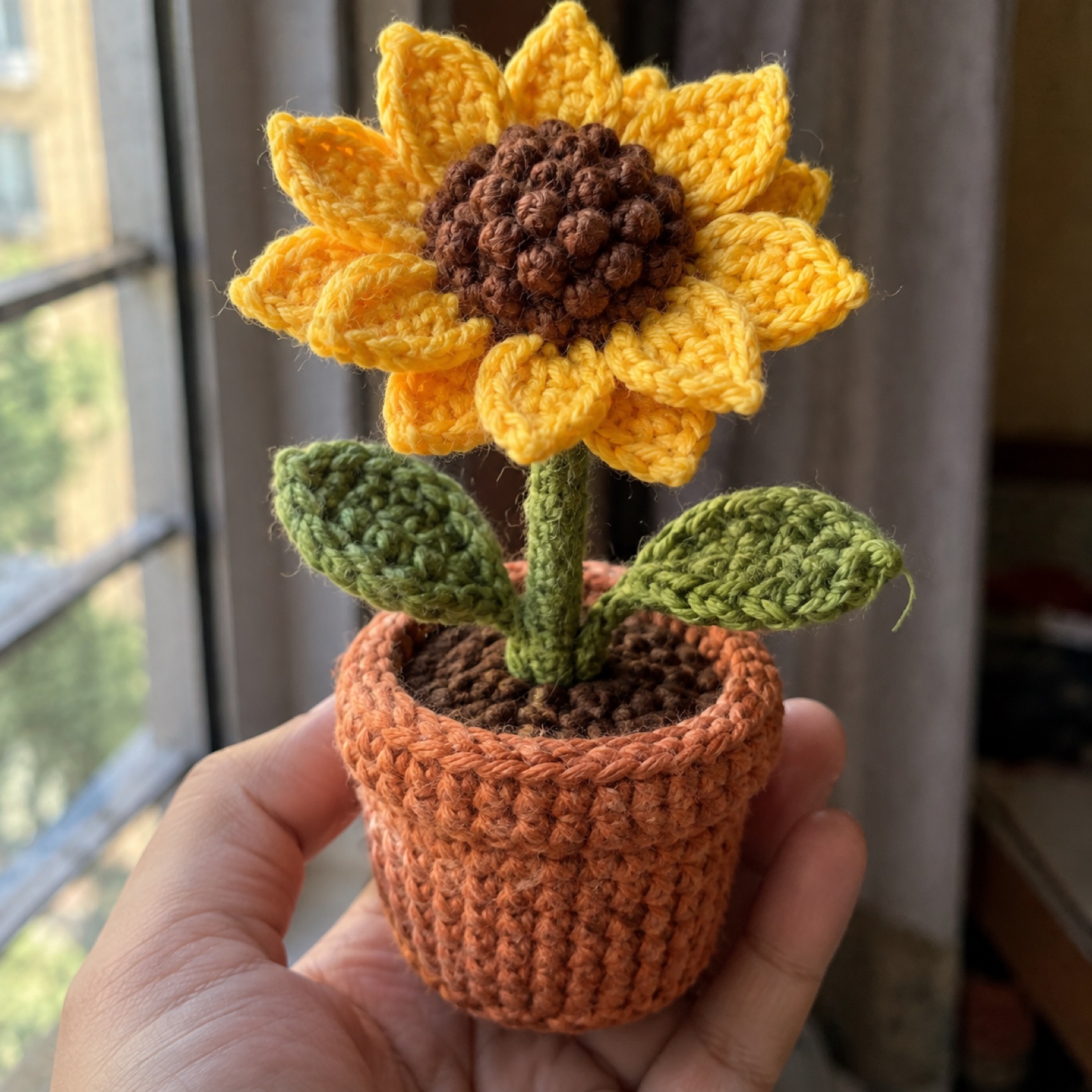 Close-up of the ribbed terracotta pot rim and the stem's base on the Potted Sunflower Desk Bloom