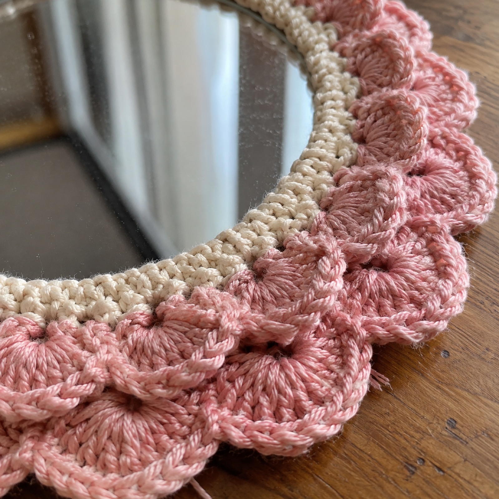 Close-up of the layered blush scallops edging the mirror on the Scallop Round Mirror