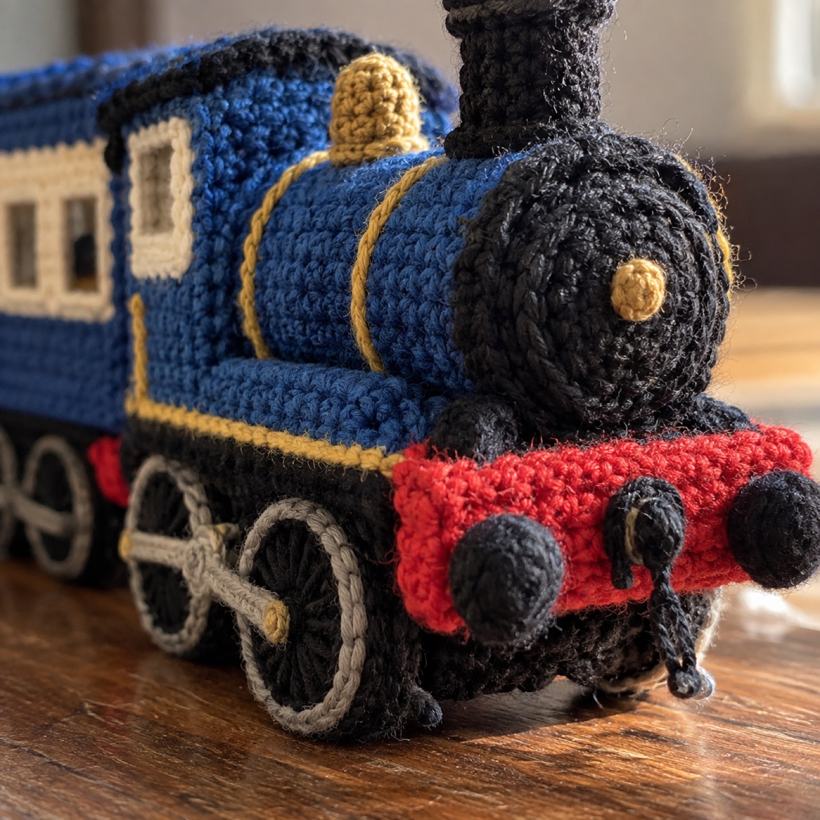 Close-up of the black wheels and red buffer beam of the engine on the DHR Toy Train Plush
